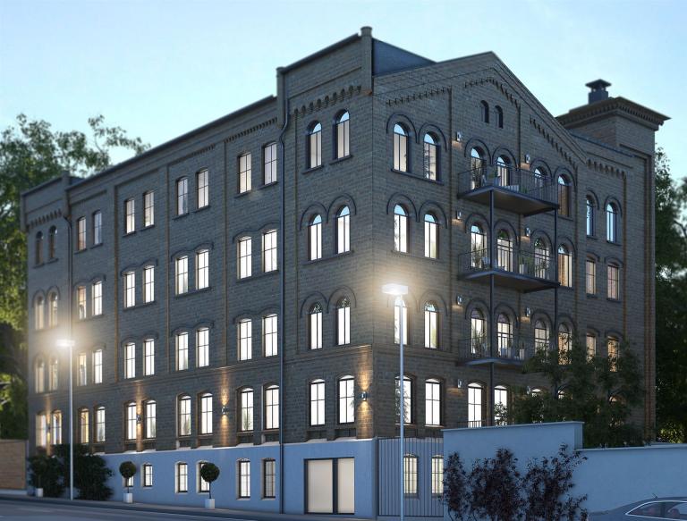 Ein großes, historisches, mehrstöckiges zu Lofts umgebautes Fabrikgebäude im klassischen Stil mit zahlreichen Fenstern und moderner Fassadengestaltung.